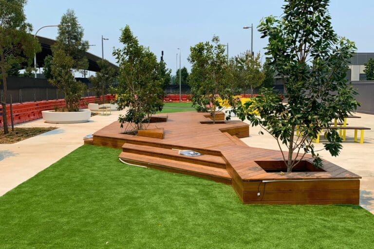 Contemporary outdoor deck with built-in seating and landscaping, designed and built by Pergola Land — examples like this can be explored at the Sydney showroom.