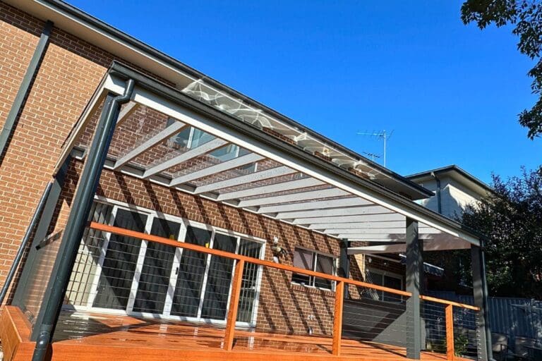 Contemporary backyard pergola with insulated polycarbonate roof and outdoor seating.